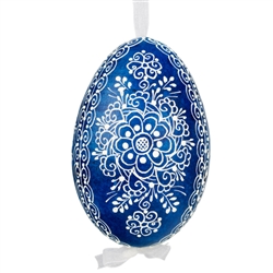 This beautifully designed egg is dyed one color, then white wax is melted and applied to form an intricate design which is left on the surfce. The egg is emptied and strung with ribbon for hanging.