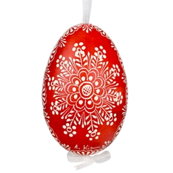 This beautifully designed egg is dyed one color, then white wax is melted and applied to form an intricate design which is left on the surfce. The egg is emptied and strung with ribbon for hanging.