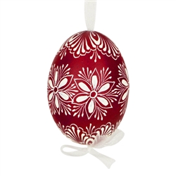 This beautifully designed egg is dyed one color, then white wax is melted and applied to form an intricate design which is left on the surfce. The egg is emptied and strung with ribbon for hanging.