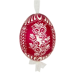 This beautifully designed egg is dyed one color, then white wax is melted and applied to form an intricate design which is left on the surfce. The egg is emptied and strung with ribbon for hanging.