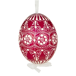 This beautifully designed egg is dyed one color, then white wax is melted and applied to form an intricate design which is left on the surfce. The egg is emptied and strung with ribbon for hanging.