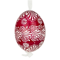 This beautifully designed egg is dyed one color, then white wax is melted and applied to form an intricate design which is left on the surfce. The egg is emptied and strung with ribbon for hanging.