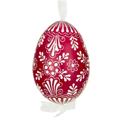 This beautifully designed egg is dyed one color, then white wax is melted and applied to form an intricate design which is left on the surfce. The egg is emptied and strung with ribbon for hanging.