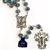 Light Blue Genuine Crystal 8mm Rosary with Painted Rose inside each Crystal Bead. 
&#8203;Double capped beads with Mother and Child center and Deluxe Crucifix.   
&#8203;Comes with a Rosary Display Case