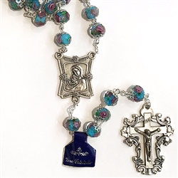 Light Blue Genuine Crystal 8mm Rosary with Painted Rose inside each Crystal Bead. 
&#8203;Double capped beads with Mother and Child center and Deluxe Crucifix.   
&#8203;Comes with a Rosary Display Case
