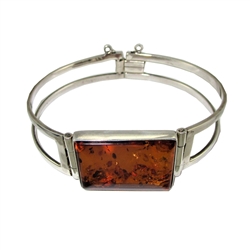 This sterling silver bracelet features a honey color amber cabochon.. Bracelet size is 7.25" diameter. Cabochon size is approx 1,25" x .25"