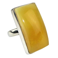 A beautiful custard color amber cabochon framed in a classic sterling silver frame. Size is approx 1" x .5".