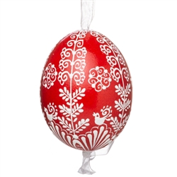 This beautifully designed egg is dyed one color, then white wax is melted and applied to form an intricate design which is left on the surfce. The egg is emptied and strung with ribbon for hanging.