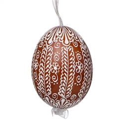 This beautifully designed egg is dyed one color, then white wax is melted and applied to form an intricate design which is left on the surfce. The egg is emptied and strung with ribbon for hanging.