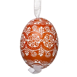 This beautifully designed egg is dyed one color, then white wax is melted and applied to form an intricate design which is left on the surfce. The egg is emptied and strung with ribbon for hanging.