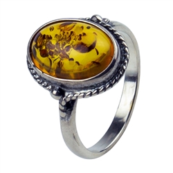 An oval of honey amber set in an artistic swirl of sterling silver.