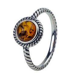 An oval of honey amber set in an artistic swirl of sterling silver.