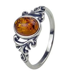 An oval of honey amber set in an artistic swirl of sterling silver.