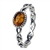 An oval of honey amber set in an artistic swirl of sterling silver.