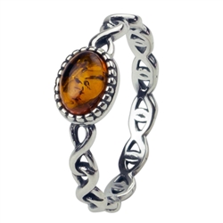 An oval of honey amber set in an artistic swirl of sterling silver.