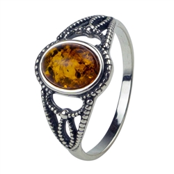 An oval of honey amber set in sterling silver with filigree detail.  Amber size is 0.25" x 0.4"