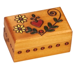 The lid of this box features a heart and flower design. Circular detailing around the sides completes the piece. Handmade in the Tatra Mountain region of Poland.