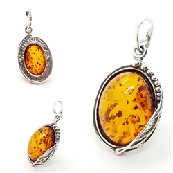Oval shaped cognac color amber stone in leaf design .925 sterling silver setting. Natural Baltic amber pendant.  Size Approx 1" x 0.5""