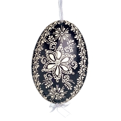 This beautifully designed egg is dyed one color, then white wax is melted and applied to form an intricate design which is left on the surfce. The egg is emptied and strung with ribbon for hanging.