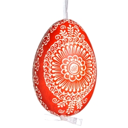 This beautifully designed egg is dyed one color, then white wax is melted and applied to form an intricate design which is left on the surfce. The egg is emptied and strung with ribbon for hanging.