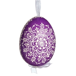 This beautifully designed egg is dyed one color, then white wax is melted and applied to form an intricate design which is left on the surfce. The egg is emptied and strung with ribbon for hanging.