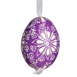 This beautifully designed egg is dyed one color, then white wax is melted and applied to form an intricate design which is left on the surfce. The egg is emptied and strung with ribbon for hanging.