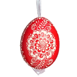 This beautifully designed egg is dyed one color, then white wax is melted and applied to form an intricate design which is left on the surfce. The egg is emptied and strung with ribbon for hanging.