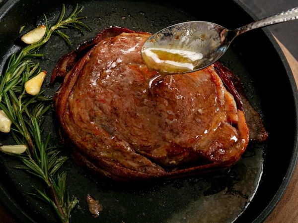 Grilled cowboy cut ribeye with herbed butter