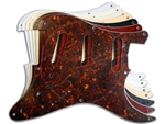 A stack of 1954-1958 Stratocaster pickguards, with a Brown Tortoise plate on the top.