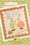 A vintage "stamp" wall hanging with an embroidered postmark and two adorable rabbits