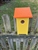 Yellow Blue Bird House with an orange roof made of composite material.  Hand made by a craftsman in the USA.