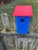 Navy Blue Bird House with a red roof made of composite material.  Hand made by a craftsman in the USA.