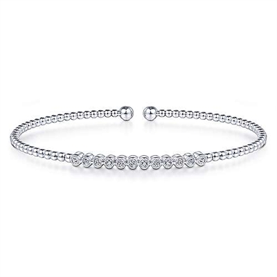 Round brilliant diamonds shimmer in this 14k white gold bezel set diamond cuff bangle style bracelet.