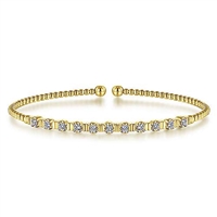 11 Round brilliant diamonds glisten in this 14k yellow gold beaded bangle bracelet.