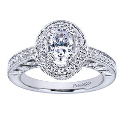 A vintage style halo engagement ring set with nearly one half carats in round brilliant diamonds fabulously decorates an oval shaped center diamond in this engagement ring available in white gold or platinum.