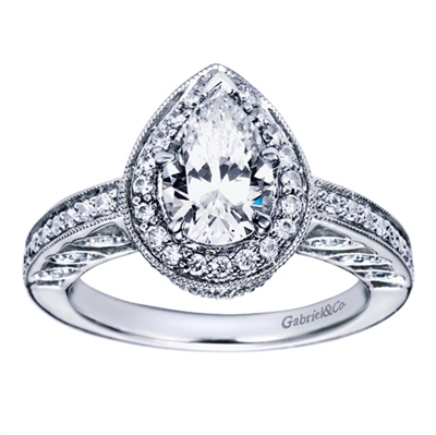 Fine metal work and round brilliant diamonds blend to form this vintage style halo engagement ring intended for a pear shape center diamond, available in white gold or platinum.
