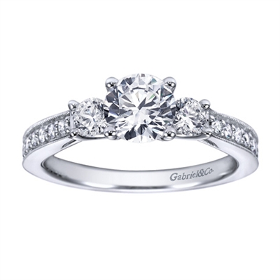 A classic 3 stone approach with a taste of the dramatic in its milgrain edging, this white gold or platinum vintage 3 stone engagement ring will light her eyes up with 12 carat of round brilliant diamonds.