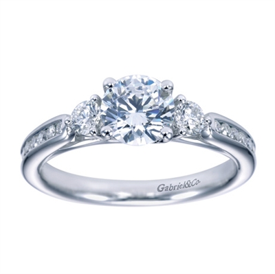 Set with brilliant round diamonds, this contemporary 3 stone engagement ring sparkles with radiance as it sits on her finger.