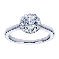 A round brilliant halo contrasts perfectly with the sleek white gold band in this contemporary halo engagement ring available in platinum or white gold.