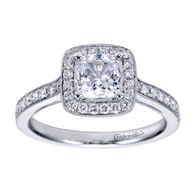 A white gold and round brilliant diamond creation that will have the round center diamond sparkling in this vintage halo engagement ring.