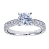 A round center diamond sits perfectly in a vintage inspired straight engagement ring with side round brilliant diamonds.