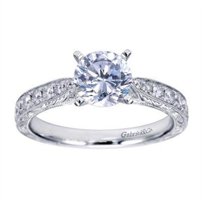 A round center diamond sits perfectly in a vintage inspired straight engagement ring with side round brilliant diamonds.