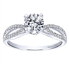 This rounded split shank engagement ring benefits from the glow of a round center diamond, featuring almost one quarter carats of round brilliant diamonds, available in white gold or platinum.