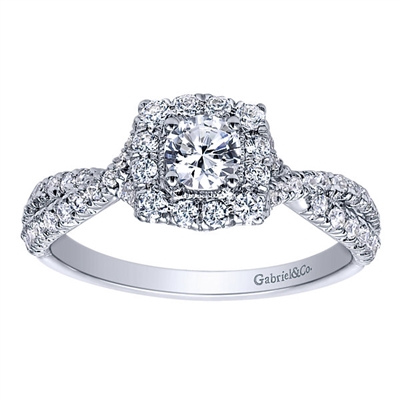 This unique and well crafted vintage style halo engagement ring features a split shank full of round brilliant diamonds and includes a round center diamond!