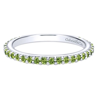 A row of peridot stones shimmer in this 14k white gold stackable ring.