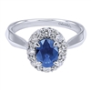A 1 carat center sapphire shines brilliantly in a round diamond halo all set in 14k white gold in this engagement ring alternative.