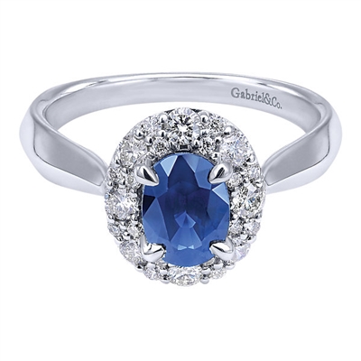 A 1 carat center sapphire shines brilliantly in a round diamond halo all set in 14k white gold in this engagement ring alternative.