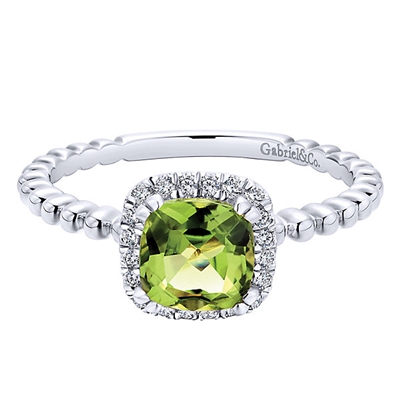 This delicate dandy features 14k white gold leading up to a peridot with a round diamond halo in this 14k white gold diamond gemstone ring.