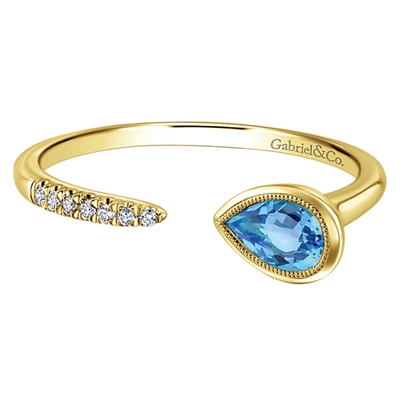 This swiss blue topaz ring features an open design with gorgeous diamonds laid over 14k yellow gold.