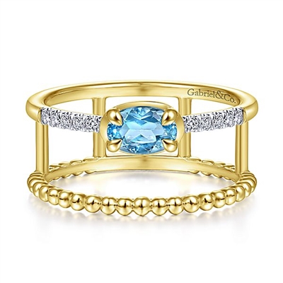 This uniquely styled 14k yellow gold diamond and blue topaz ring features beaded 14k yellow gold.